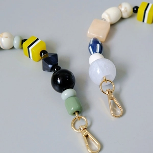 Detail of colorful acrylic bead bag chains with vintage handmade resin beads and gold clasps