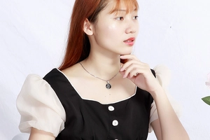 Model wearing a gold stainless steel Tree of Life pendant with black enamel finish