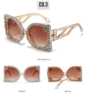 Macro detail of oversized square sunglasses featuring champagne frames and rhinestone edges