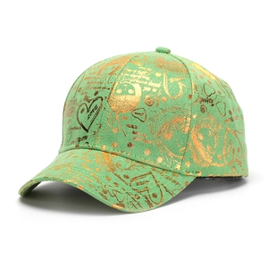 Détail d'une casquette vert clair avec des motifs de cœurs dorés et l'inscription LOVE