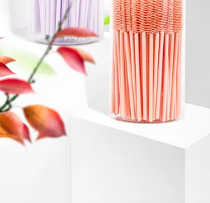 Macro view of disposable spiral eyelash brushes in storage tube on a white stand