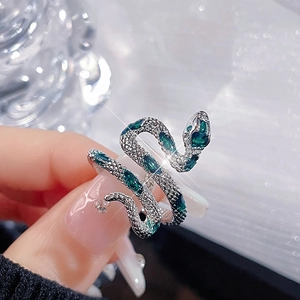 Macro shot of a vintage silver snake ring with sparkling green zircon stones on band
