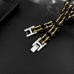 Detail of two-tone black and gold stainless steel bike chain bracelet on leather