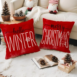 Detail of red Christmas pillow covers with winter greetings on a cozy sofa