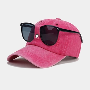 Detailed side view of a rose pink vintage baseball cap featuring built-in black sunglasses