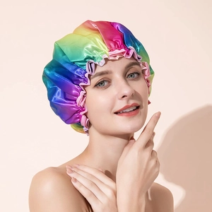 Close-up of rainbow satin shower cap with elastic pink ruffle edge on female model