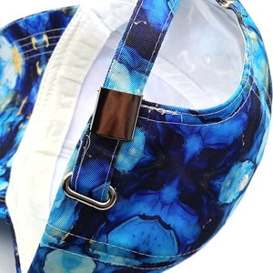 Macro view of tie-dye baseball cap with silver metal buckle and marble pattern texture