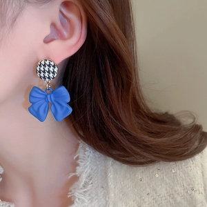 Blue bow earrings with houndstock pattern shown on model side profile view