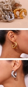 Detail view of chunky hollow C-hoop earrings in polished gold and silver metallic finish