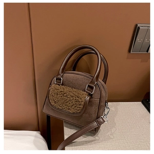 Detailed view of dark brown plush handbag with teddy fur pocket and silver metal hardware