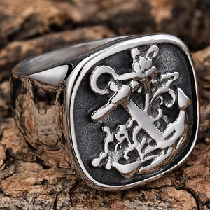Detailed view of men's vintage stainless steel anchor signet ring on natural wood
