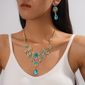 Detail of vintage gold flower jewelry set with sky blue crystals worn by a model