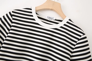 Close-up of black and white striped t-shirt collar with M-size label and wood hanger