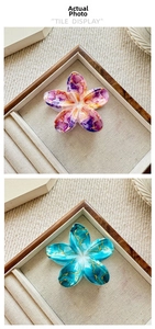 Detailed view of floral hair claws featuring purple marble and blue gold-veined resin patterns