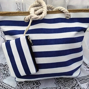 Close-up of blue white striped canvas tote set with rope handles on lace fabric