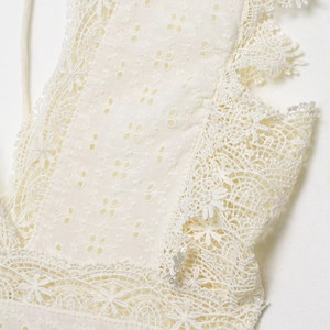 Elegante abito bianco in pizzo con ricami floreali e raffinati dettagli intagliati