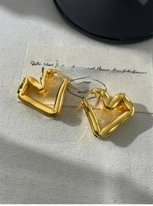 Close-up of S925 sterling silver golden fluid heart earrings with elegant twisted texture