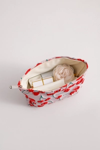 Detail view of cherry print canvas makeup bag with internal storage for skincare items