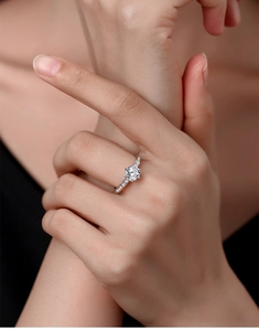 Close-up of a sterling silver ring with a round-cut stone and pavé-set diamond band