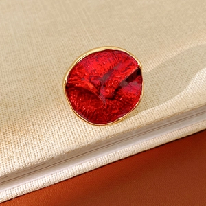 Macro shot of a vintage gold-plated red enamel ring resting on a book with leather background