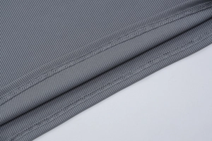 Gros plan détaillé sur la texture en tricot côtelé gris et la qualité de couture à double aiguille