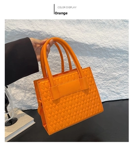Details einer leuchtend orangefarbenen Umhängetasche mit geometrischem Steppmuster und PU-Leder