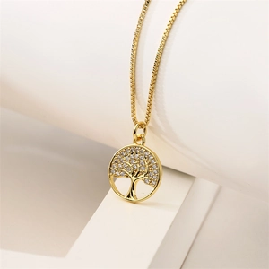Detail of gold tree of life pendant necklace featuring shimmering inlaid crystals