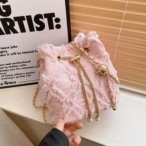 Pink denim bucket bag with diamond quilted texture and elegant gold chain strap