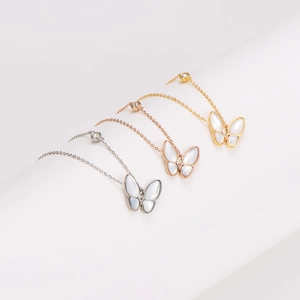 Three butterfly necklaces in silver, gold, and rose gold with shimmering shell inlay