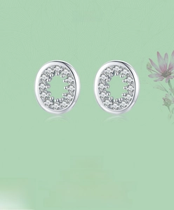 Gros plan sur des boucles d'oreilles ovales en argent avec pavé de zircons fins