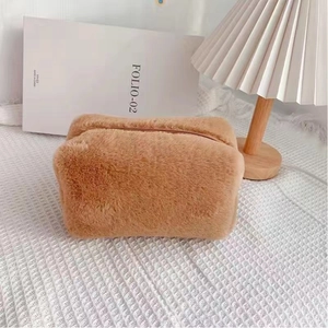 Detailed view of brown plush cosmetic bag with soft texture and smooth metal zipper