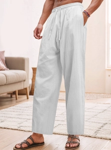 Dettaglio di pantaloni in lino bianco con vita regolabile con coulisse e tasche laterali