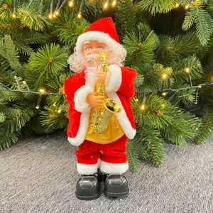 Electric Santa Claus figurine with golden saxophone and festive red suit by Christmas tree