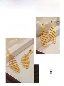 Detailed macro view of 18K gold-plated stainless steel fishbone dangle earrings