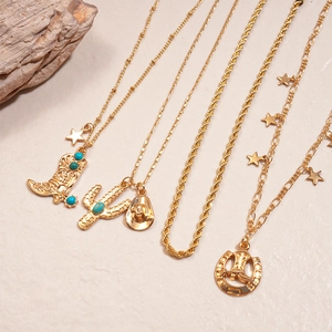 Detail of gold multi-layer necklace with cactus, cowboy boot, and turquoise pendants