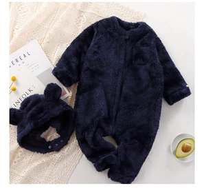 Detail view of plush navy baby romper with bear ears hat and soft coral fleece texture