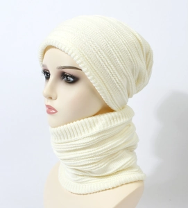 Close-up of cream knit beanie and scarf set featuring textured thick ribbed patterns