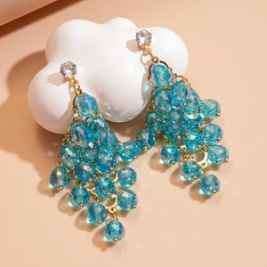 Detailed macro view of vibrant blue crystal tassel earrings with gold-toned metal accents