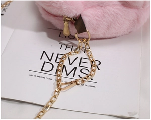 Detailed macro view of pink plush fabric with premium gold metal zipper and chain strap
