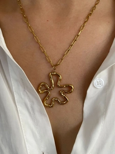 Close-up of gold paperclip chain necklace with a modern abstract wavy hollow pendant