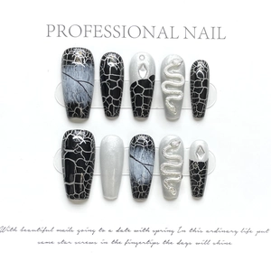 Detail of coffin nails with marble art, silver glitter, and 3D metallic snake charms