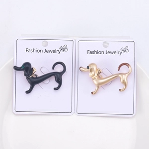 Detail of cute dachshund dog brooches in black and gold finish on jewelry display cards