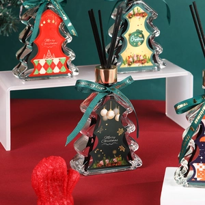Christmas tree reed diffuser gift set with glass bottles and festive ribbons in holiday setting