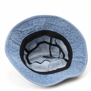 Detail of blue denim bucket hat interior showing black sweatband and neat stitching