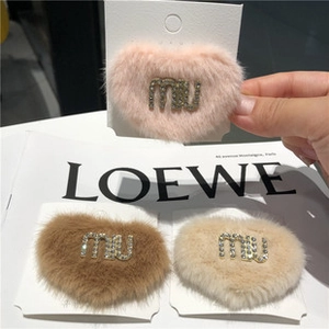 Détail de barrettes à cheveux en peluche en forme de cœur avec accents de strass brillants