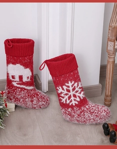 Close-up of red knitted Christmas stockings with snowflake and house patterns for decor