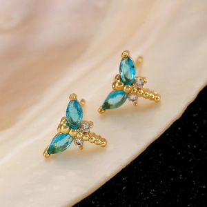 Makroaufnahme von Libellen-Ohrsteckern mit blauen Marquise-Steinen und Goldauflage