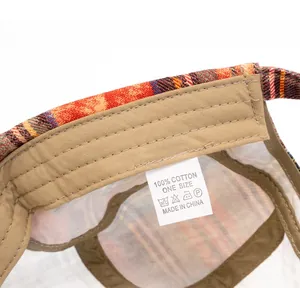 Detailed view of the 100% cotton care label and internal stitching on the plaid beret