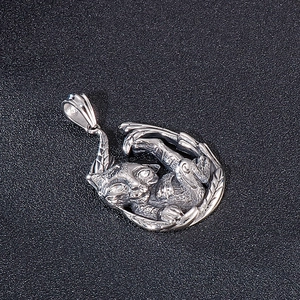 Detailed view of a silver sleeping cat pendant crafted from titanium steel on black background