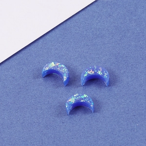 Close-up of three blue resin crescent moon opal beads for DIY jewelry making
